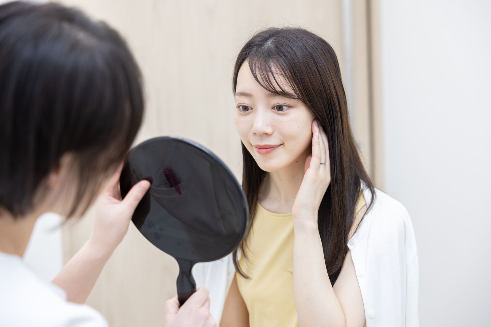専門医が手鏡で肌の状態を確認する診療